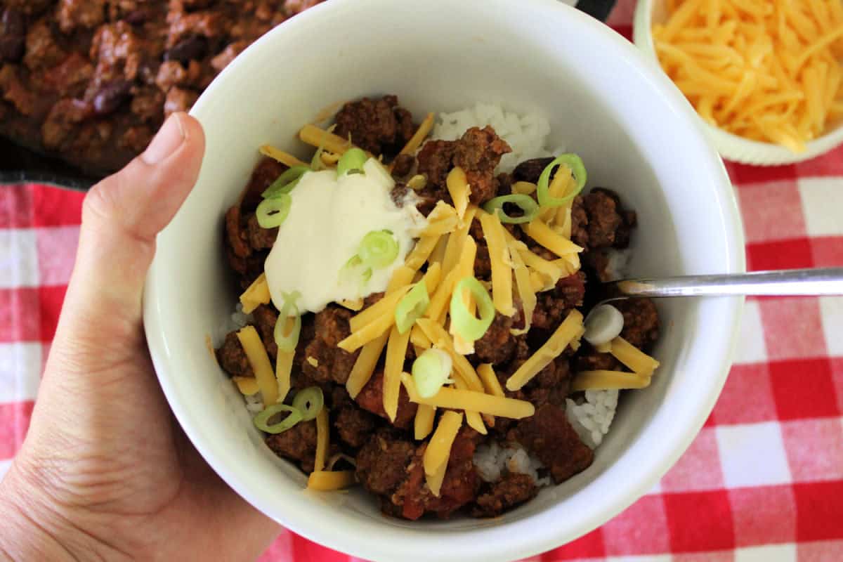 bowl of Hawaiian style chili topped with cheese, sour cream, and green onions