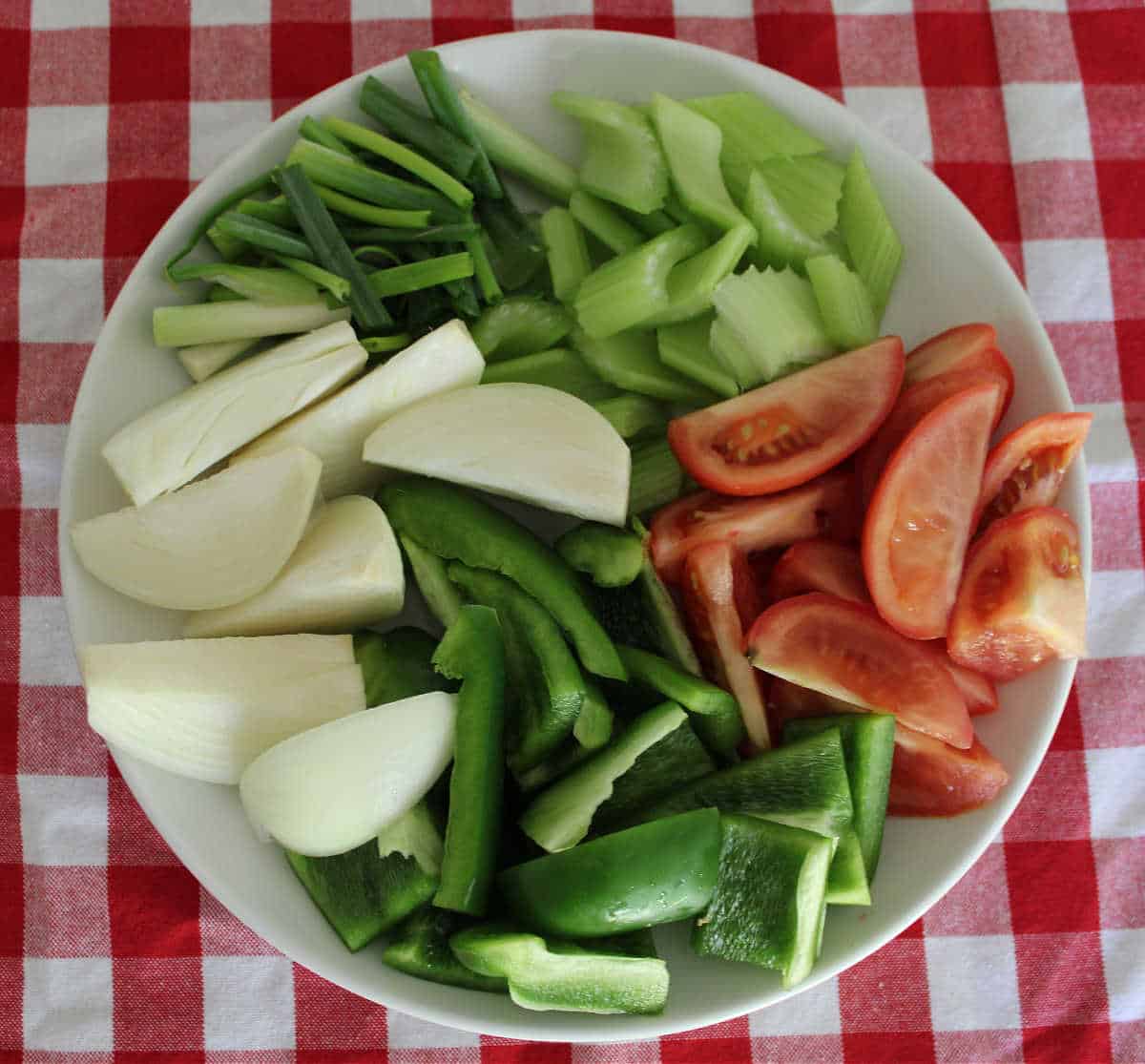 cut up vegetables on a white plate