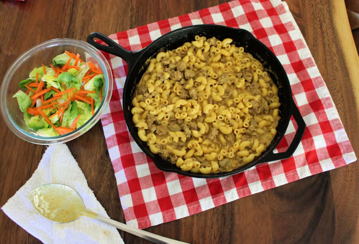 hamburger helper in a black cast iron skillet served with a green salad