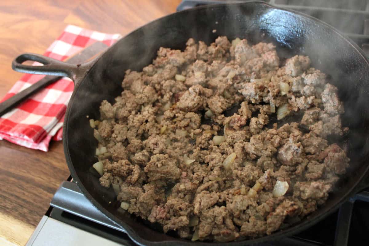 ground beef being brown in skillet with onions