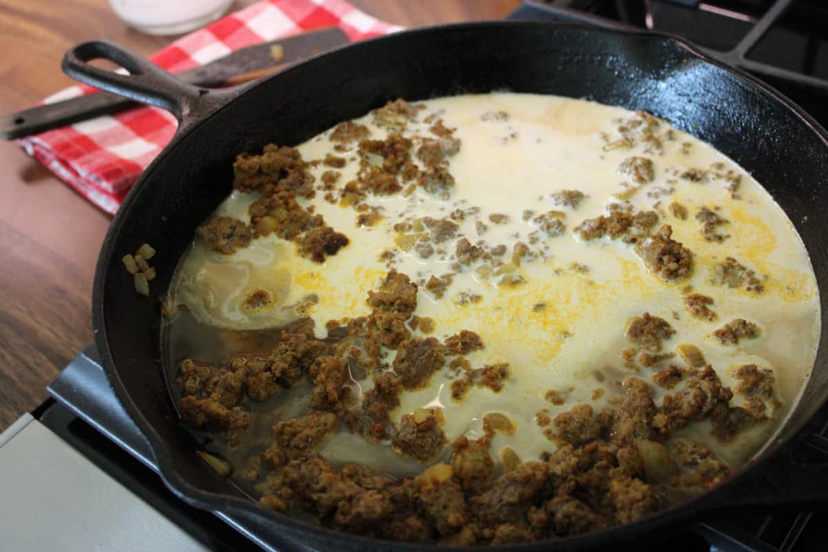 beef broth and heavy cream being added to beef mixture