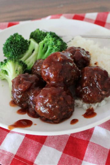 sweet and sour meatballs on a plate served with white rice and steamed broccoli