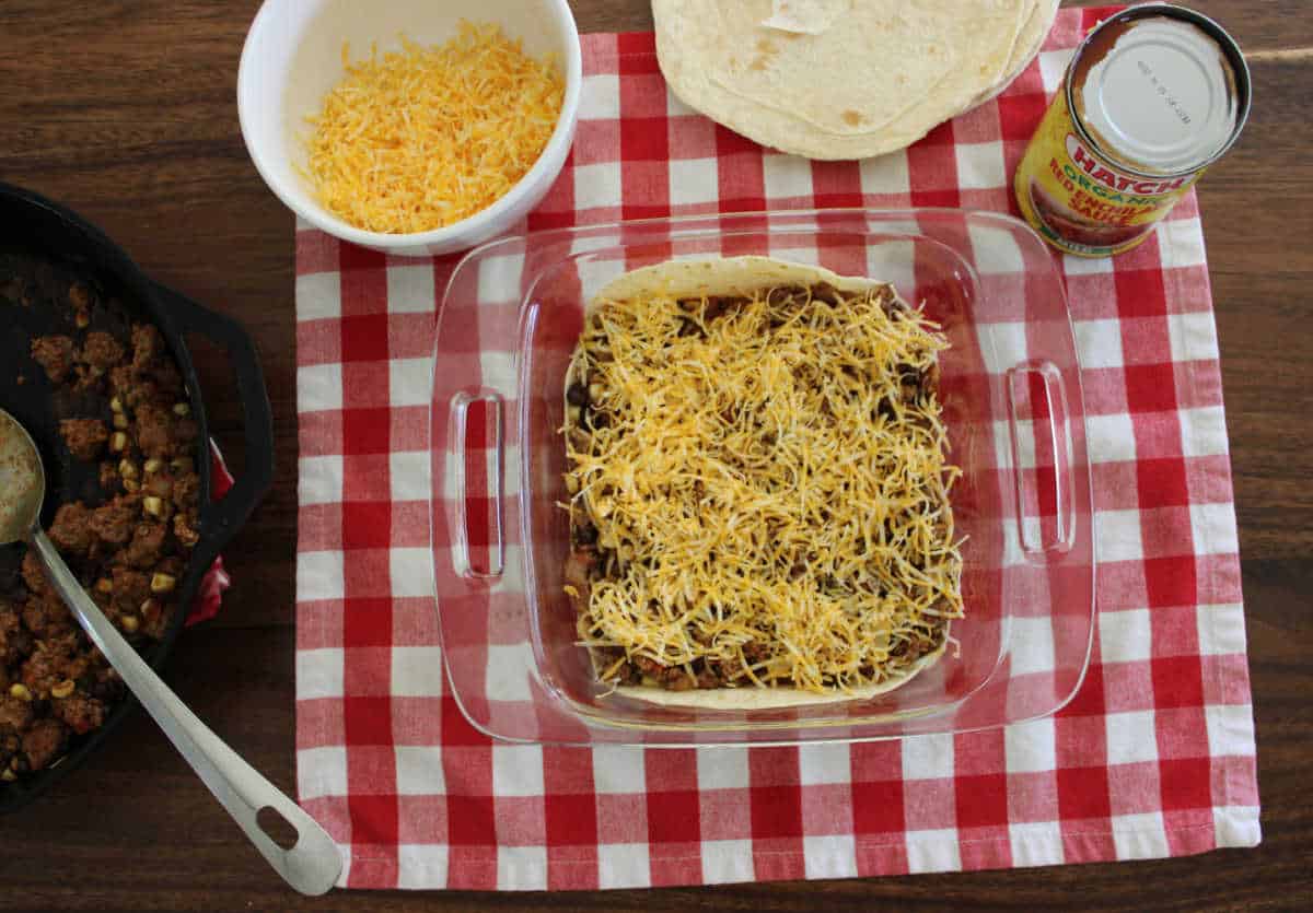 casserole being topped with grated cheese