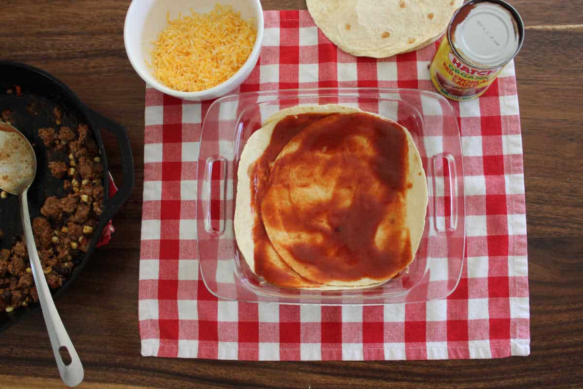 red enchilada sauce on the top of the casserole