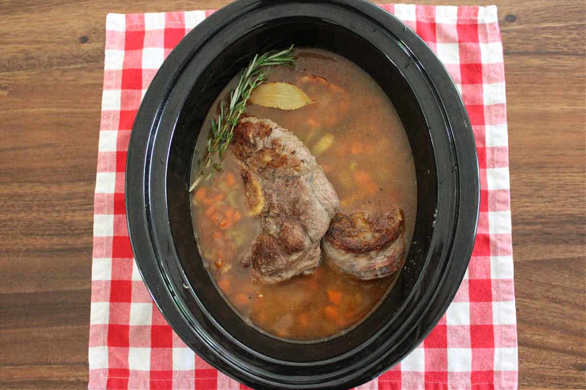 beef shanks, diced vegetables, and broth in a black crock pot