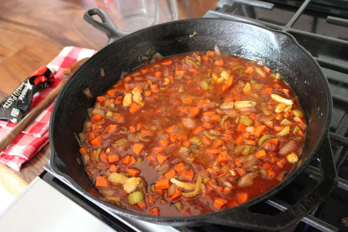 a wine whine and tomato paste sauce being reduced in a cast iron skillet