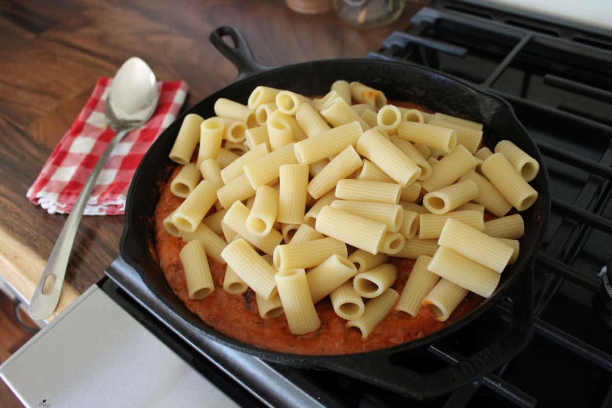 rigatoni pasta being added to marinara