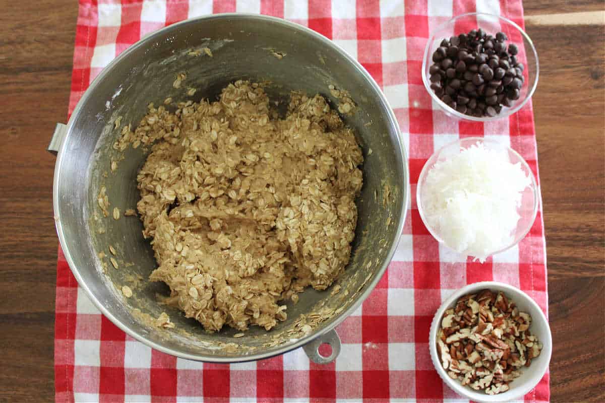a bowl of oatmeal cookie dough with add ins on the side