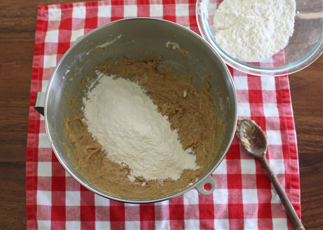 flour being added to the wet ingredients for cowboy cookies