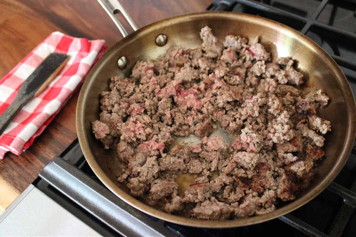 Browned ground beef in a pan.