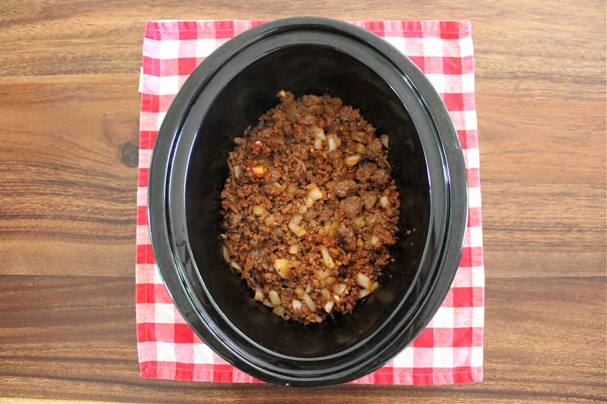 Browned ground beef in a slow cooker.