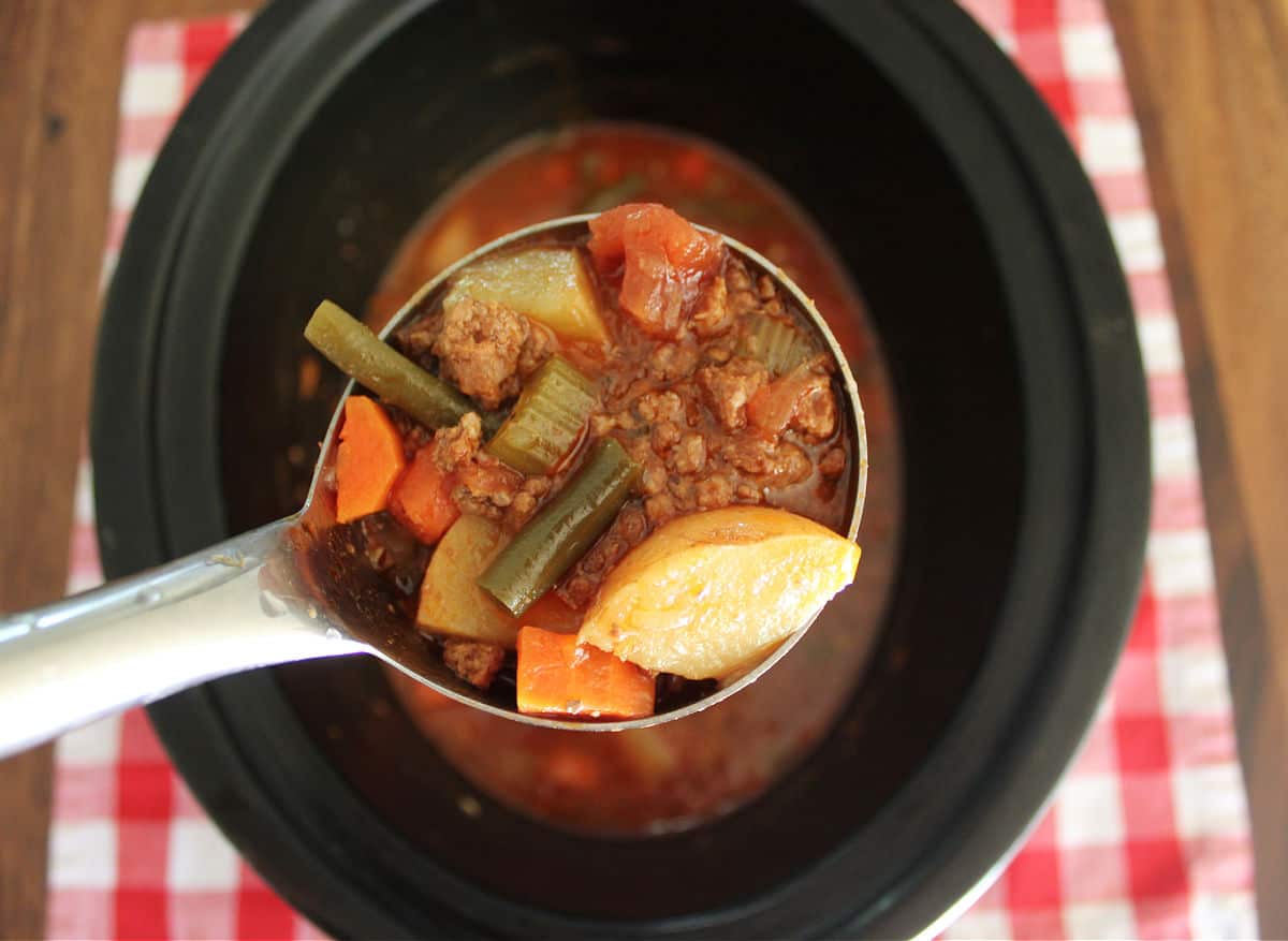 A ladle of poor mans stew being scoop from a slow cooker.