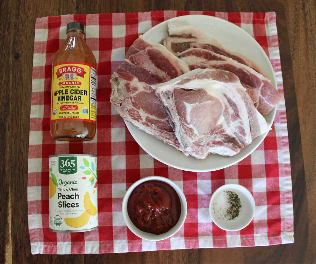 An over head ingredient shot of slow cooker pork chops and peaches.