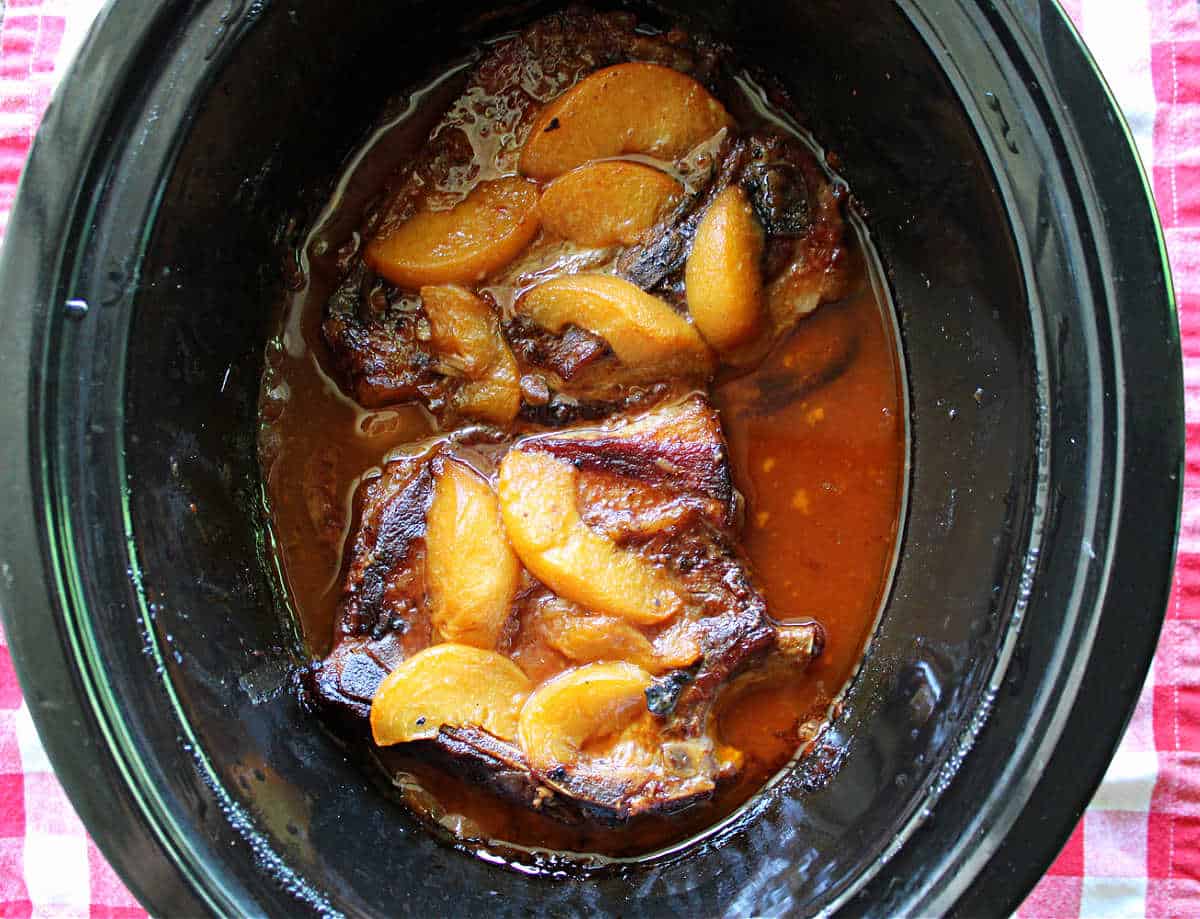 Cooked pork chops in a red peach bbq sauce.