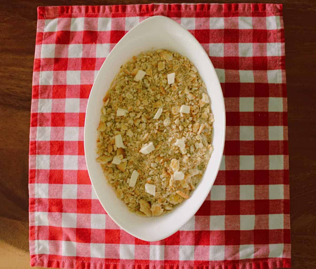 small white casserole dish of yellow squash casserole